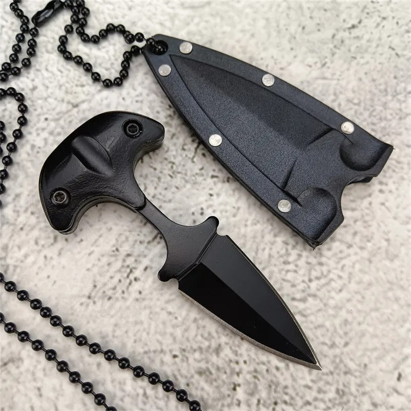 Black knife with sheath and necklace chain on a textured surface