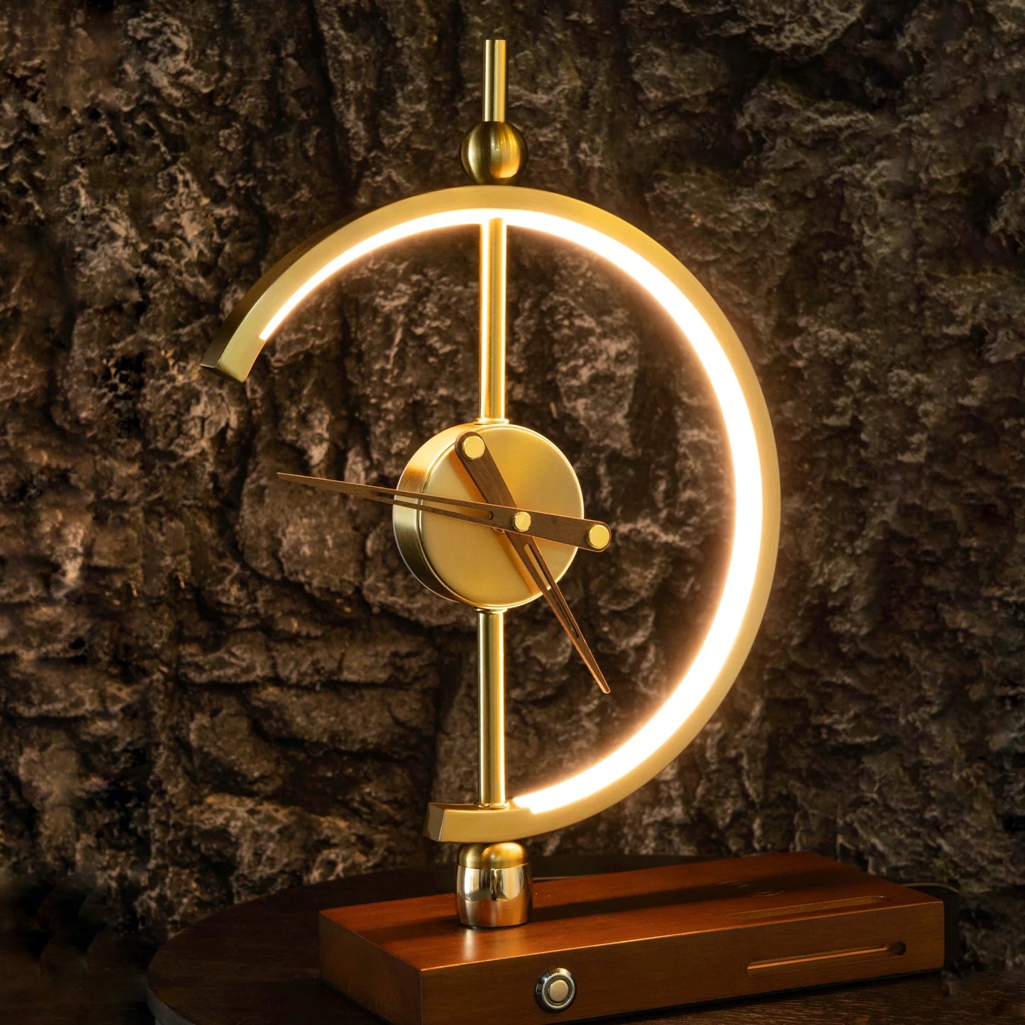 GoldenArc Desk Clock & Lamp – Modern Brass with Wireless Charger & USB, stone wall background.