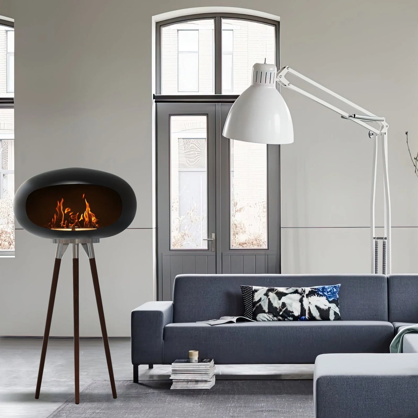 Rustic Flame Tripod Ethanol Fireplace providing cozy warmth in a modern living room setting next to lamp.