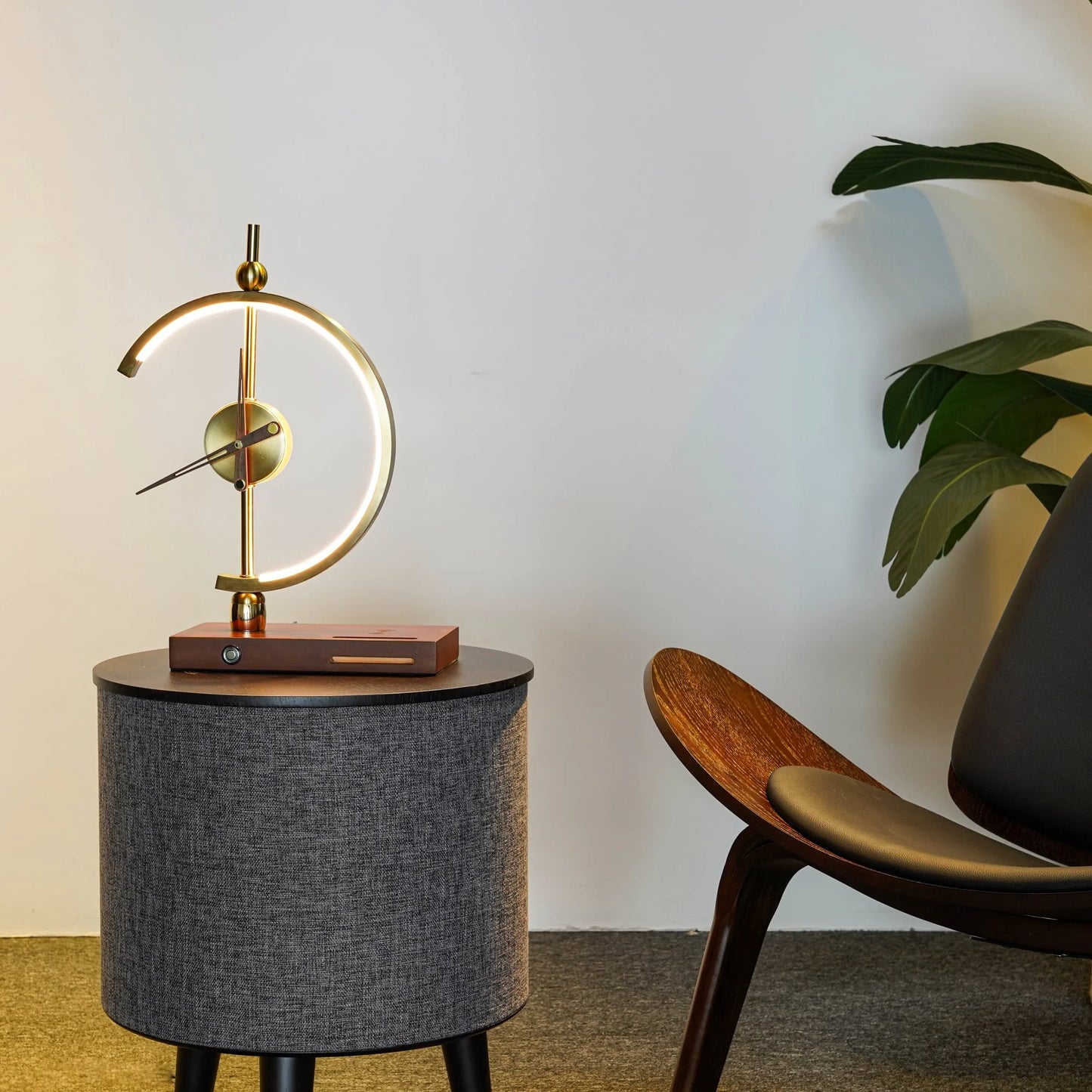 GoldenArc Desk Clock & Lamp – in office lobby, on end table next to chair.